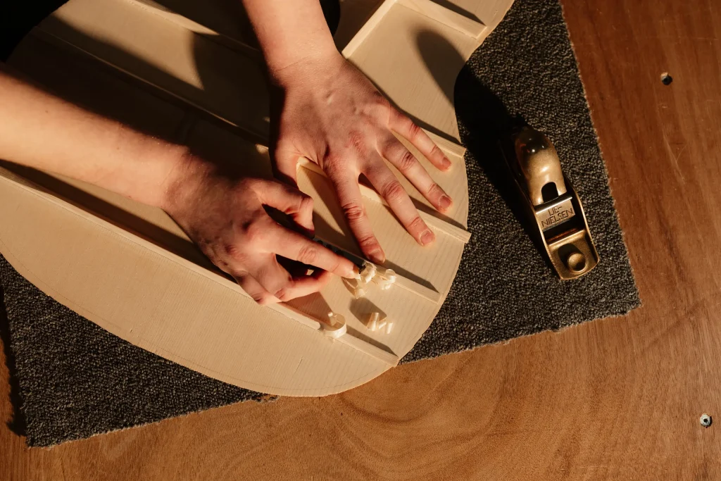 Luthier posant les barres de renfort sur la table d'harmonie d'une guitare acoustique