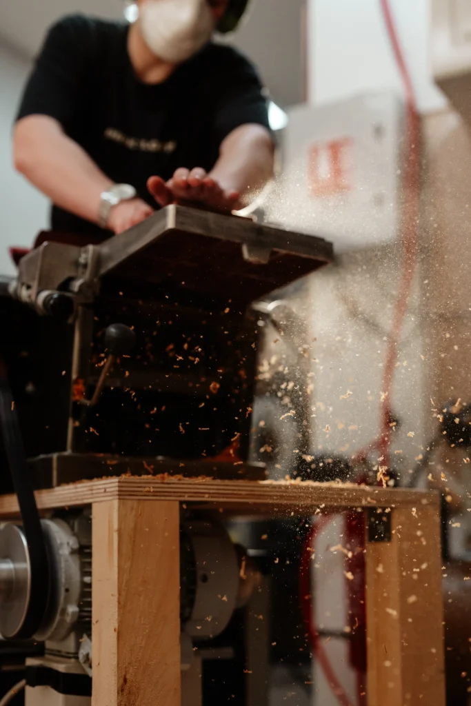 Luthier travaillant le bois à la dégauchisseuse dans un atelier de lutherie