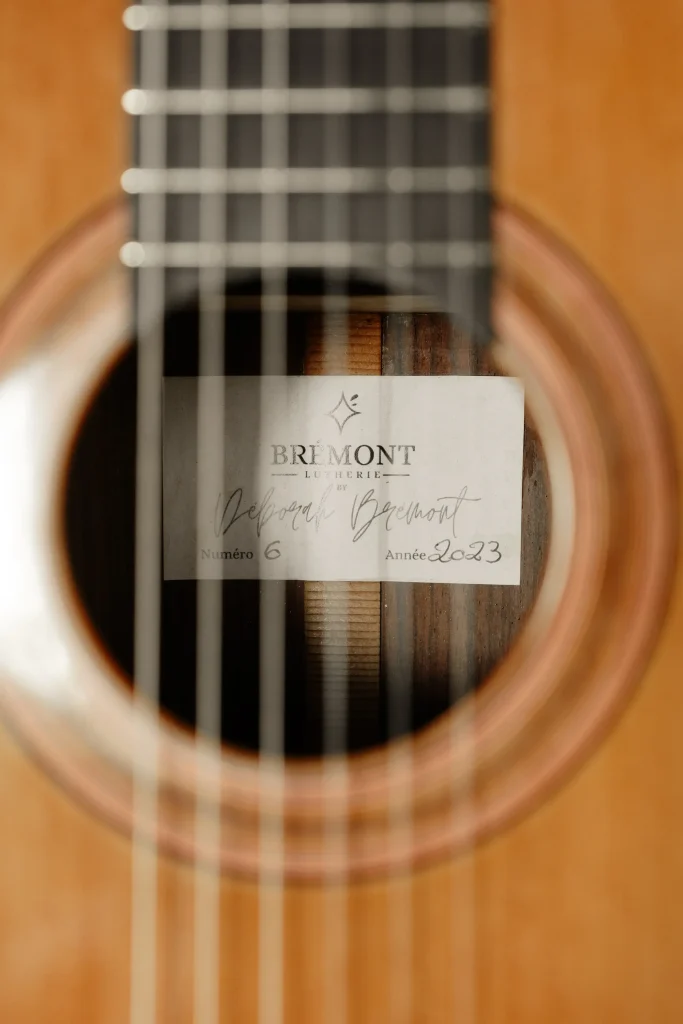 15:24Étiquette Brémont Lutherie signée par Deborah Brémont visible dans la rosace d'une guitare classique artisanale